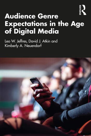 Image of cover of book, titled Audience Genre Expectations in the Age of Digital Media, showing a photo of a closeup of a person’s hand holding a smart phone while seated in a theater with other audience members.